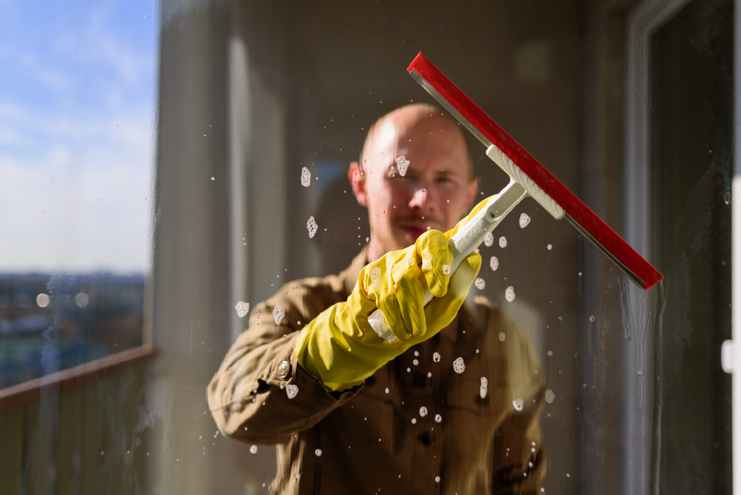 man washing window in yellow rubber gloves 2025 03 05 22 49 23 utc scaled